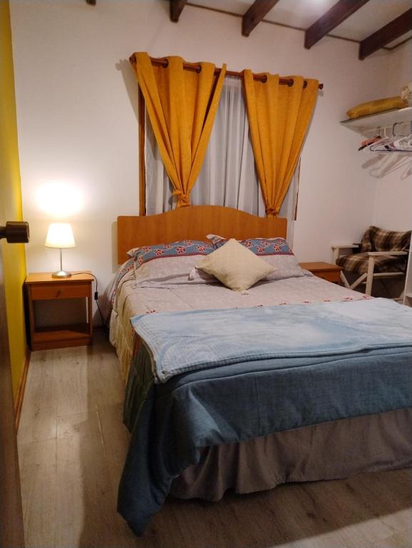 Schlafzimmer mit einem Bett und einem Fenster mit Vorhängen in der Unterkunft Playa Los Molles , lindo lugar , cómoda cabaña, ideal para descansar , los esperamos 24 7 in Los Molles