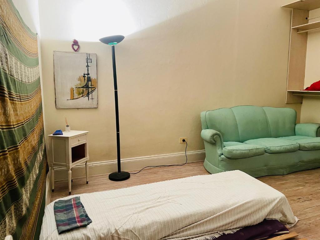 a living room with a green couch and a lamp at Amplia Habitacion en San Telmo in Buenos Aires