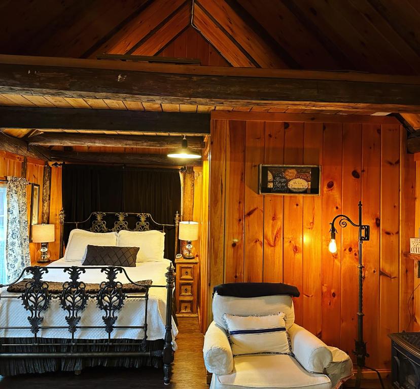 um quarto com uma cama e uma cadeira em Romantic, Tranquil Guest House em Fitzwilliam