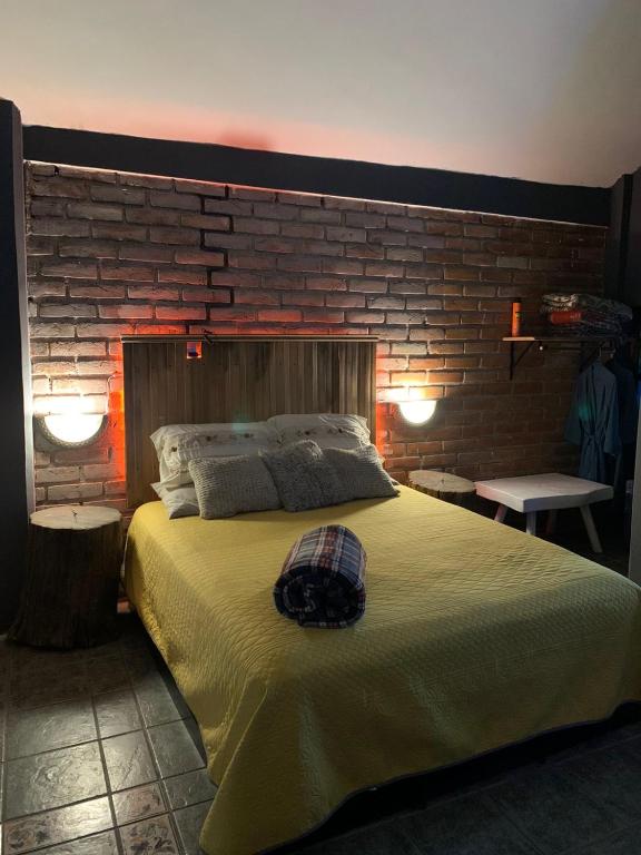a bedroom with a large bed with a brick wall at Casa Victoria in Acámbaro