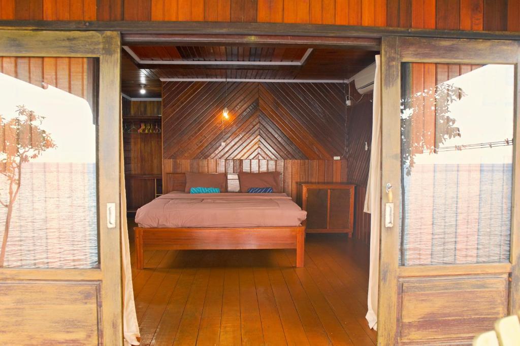 Tempat tidur dalam kamar di Maratua Guesthouse