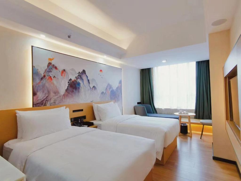 a hotel room with two beds and a couch at Connar Hotel - Shenzhen Shawei in Shenzhen