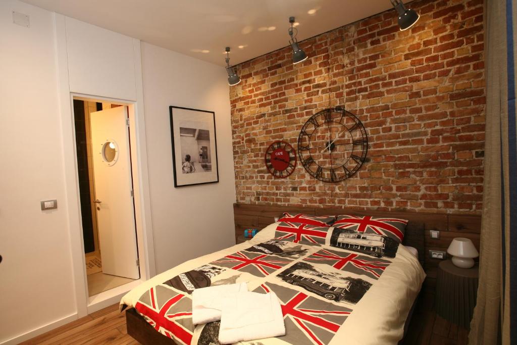 a bed in a bedroom with a brick wall at City Place Apartments in Belgrade