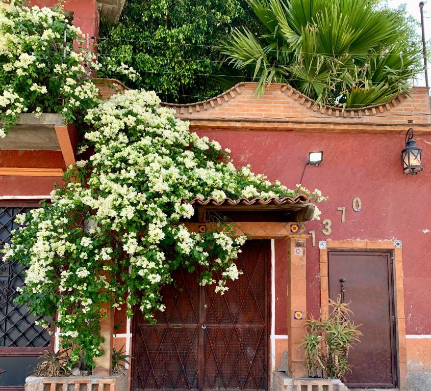 ein Gebäude mit weißen Blumen, die über einer Tür wachsen in der Unterkunft Casa Victoria in Acámbaro