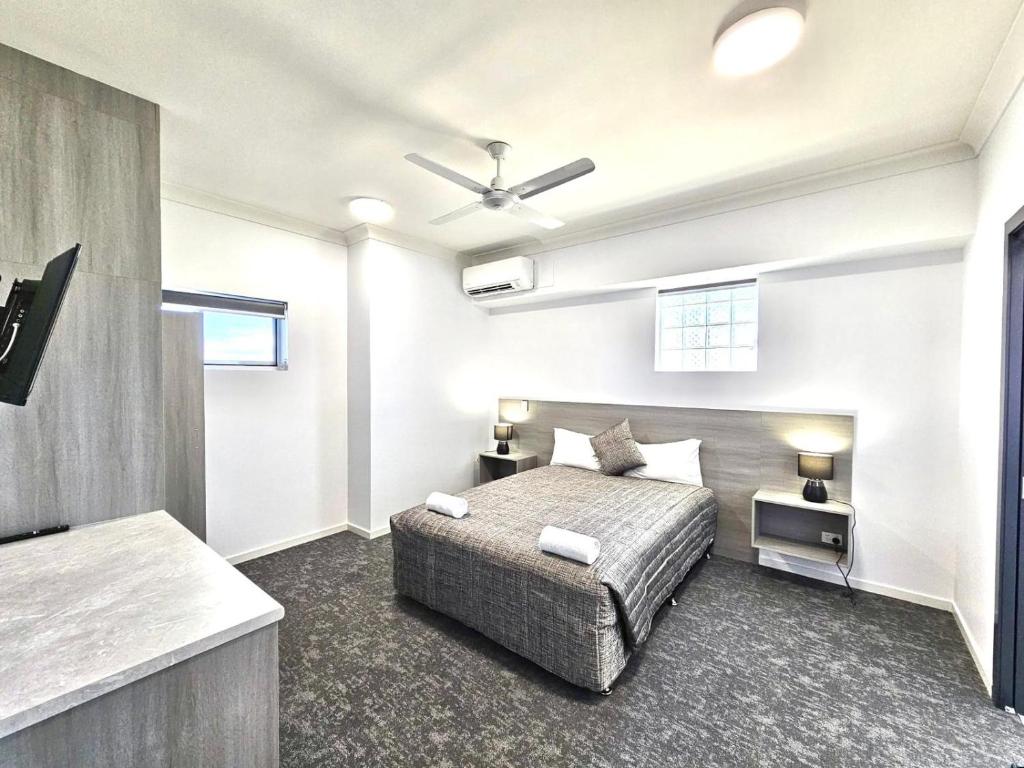 1 dormitorio con 1 cama y ventilador de techo en Y Motels Rockhampton en Rockhampton