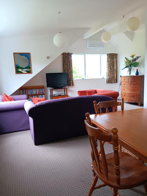 a living room with a couch and a table at Purple Hen Country Lodge in Katikati