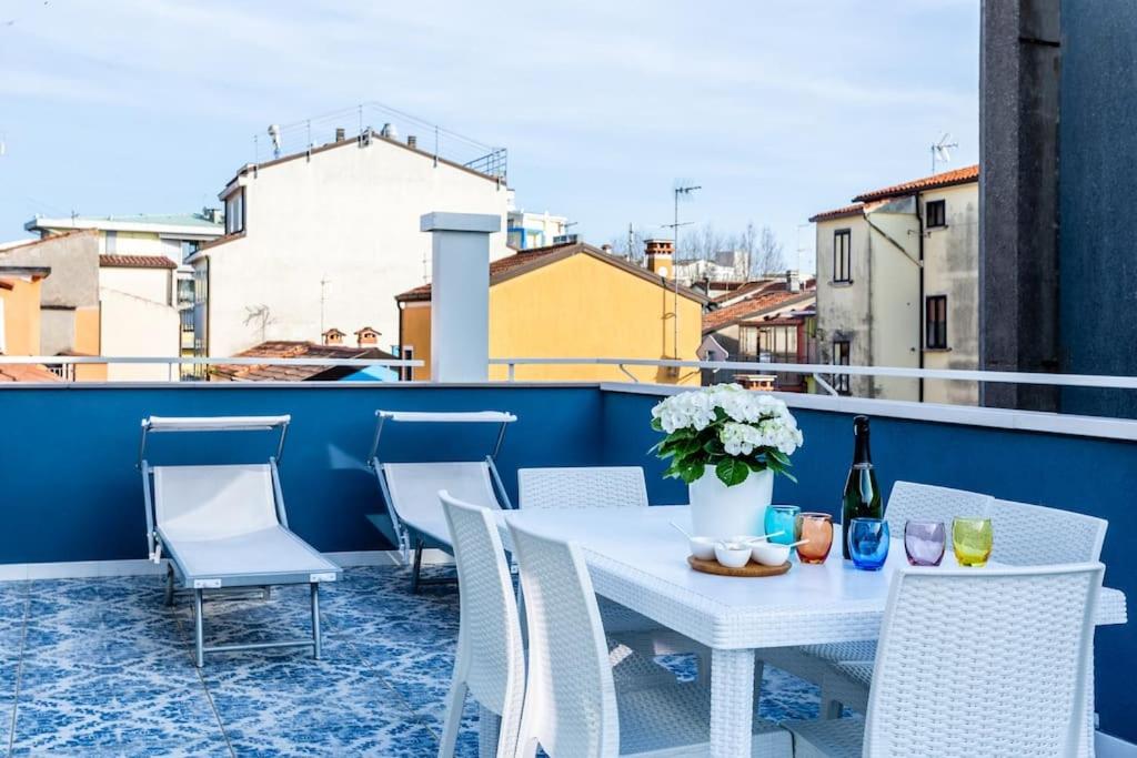 een witte tafel en stoelen op een balkon bij La Bella Vita - La Terrazza in Sottomarina