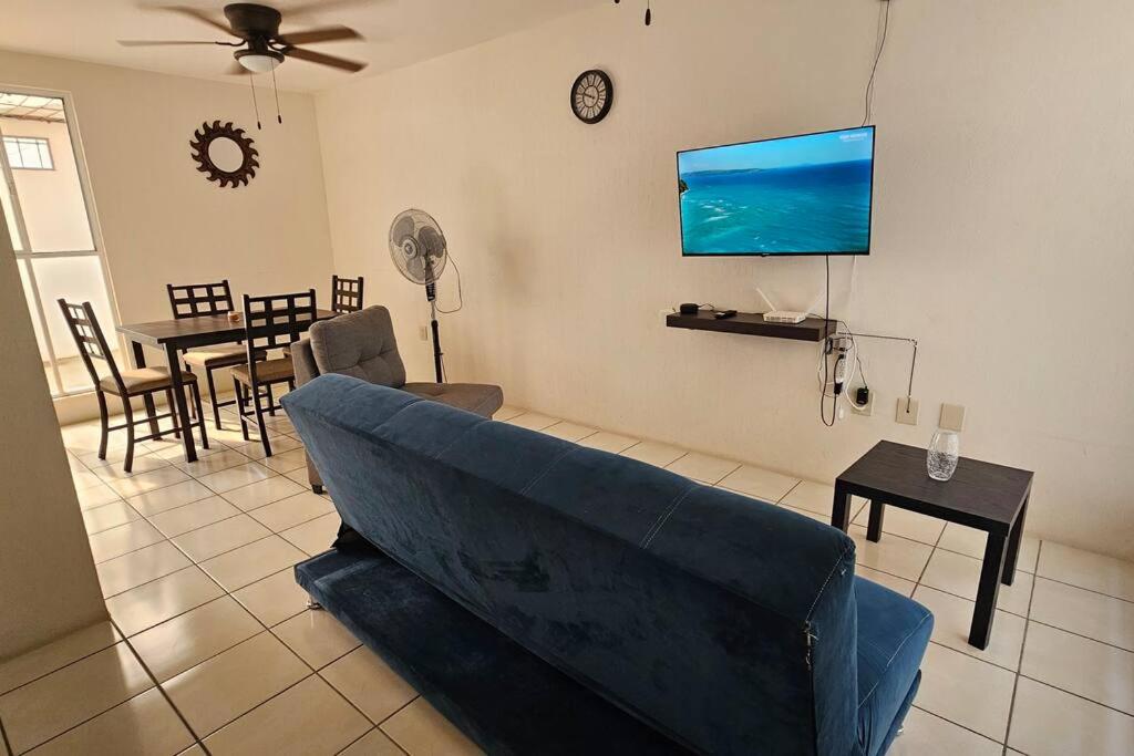 uma sala de estar com um sofá azul e uma mesa em Allissons House Cómoda Casa con Alberca y Quiosco em Emiliano Zapata