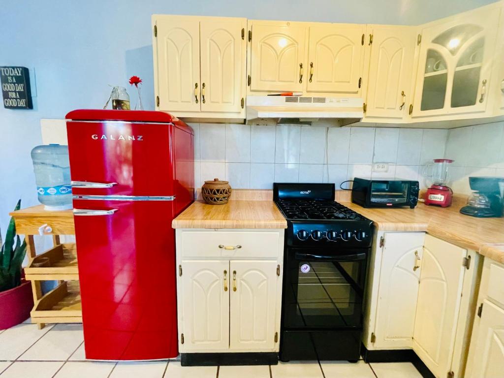 um frigorífico vermelho numa cozinha com armários brancos em Casa Kante em San José del Cabo