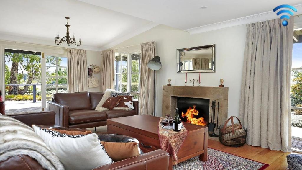 a living room with a couch and a fireplace at Duncraig House in Bundanoon