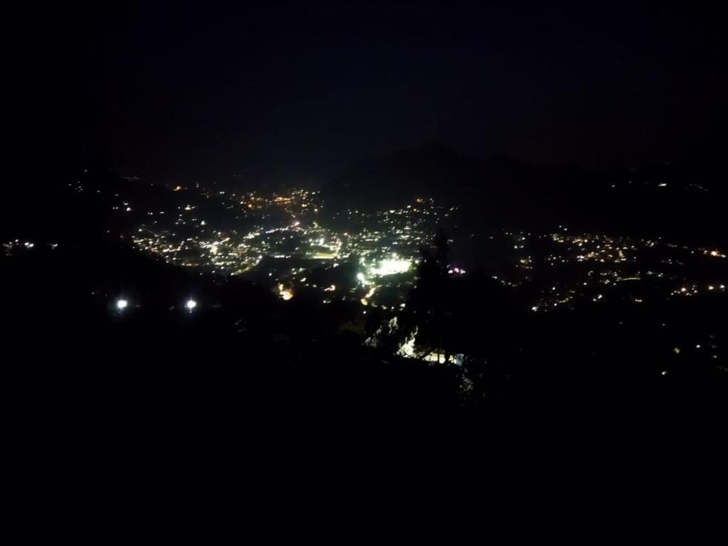 vista sulla città illuminata di notte di Kumaon Lake's Home stay a Nainital