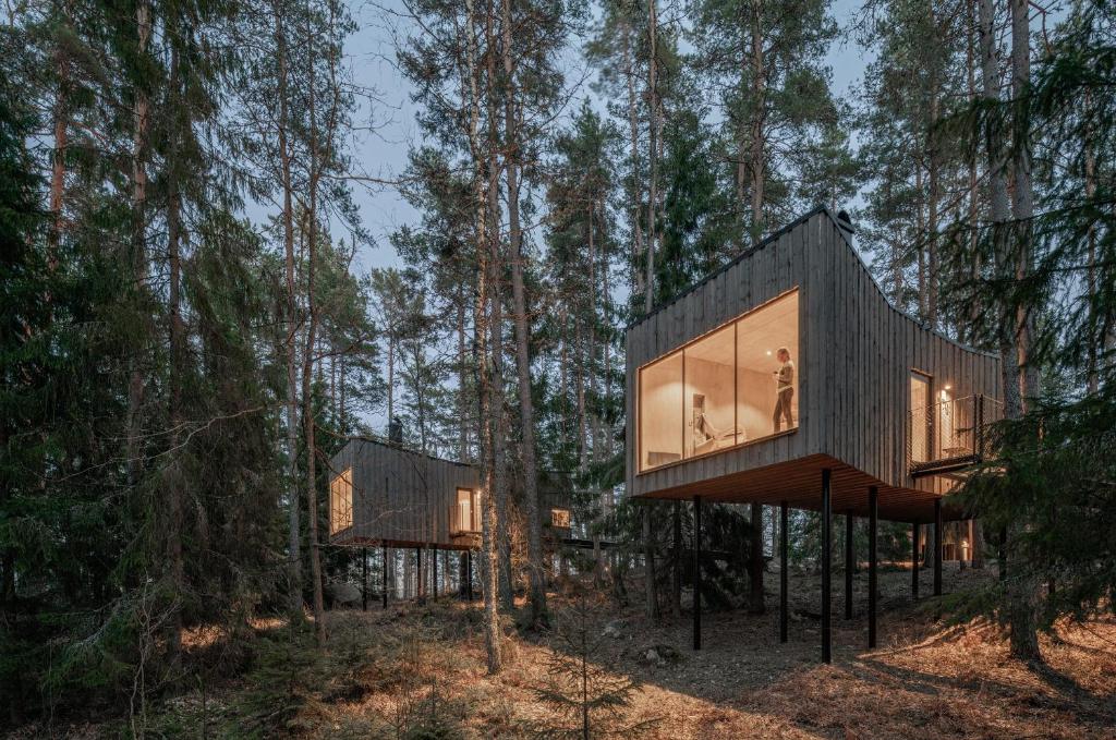 una casa en el bosque con una fachada de cristal en Trakt Forest Hotel, en Holsbybrunn