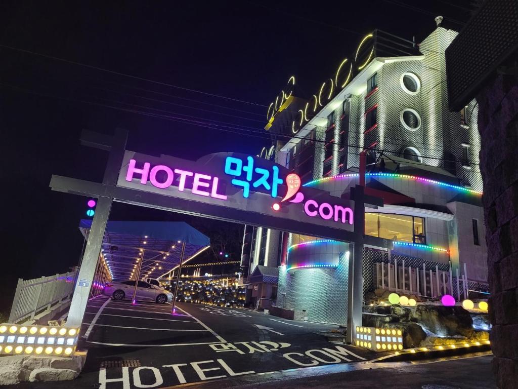 蔚山的住宿－Hotel Eat Dot Com Alpeuseu Oncheon，夜间在大楼前的酒店标志