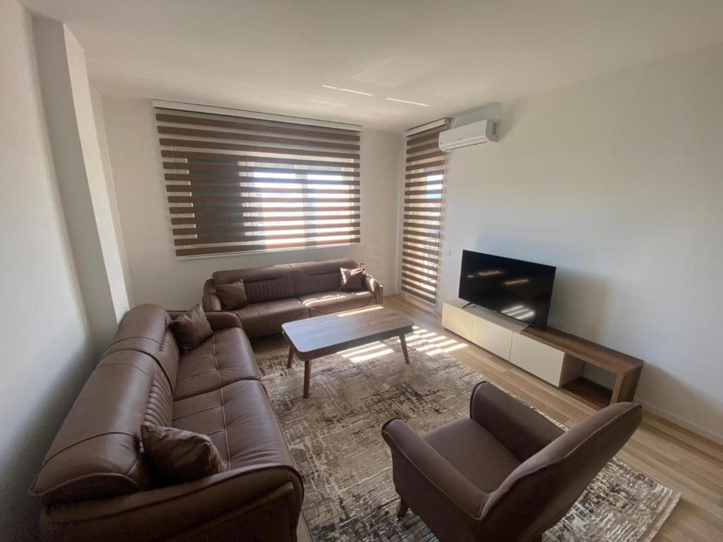 - un salon avec un canapé en cuir et une table dans l'établissement Tregu Fatoni #2 prizren city 3 bedroom apartment, à Prizren