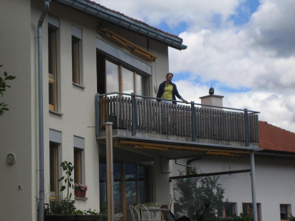 a woman standing on a balcony of a building at Senda 517 C in Scuol