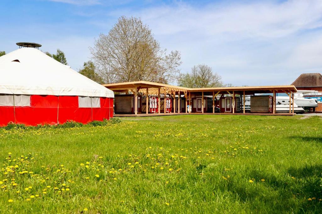 une tente rouge et blanche dans un champ d'herbe dans l'établissement Boot & Bike Hansestadt Anklam, à Anklam
