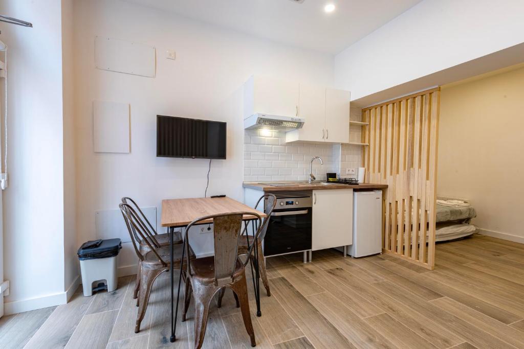 eine Küche und ein Esszimmer mit einem Tisch und Stühlen in der Unterkunft Madrid, Centro, Cuatro caminos A in Madrid