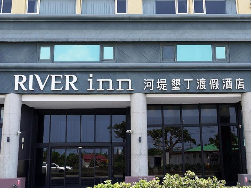un cartello River Inn sulla parte anteriore di un edificio di River Inn Kenting a Città Vecchia di Hengchun
