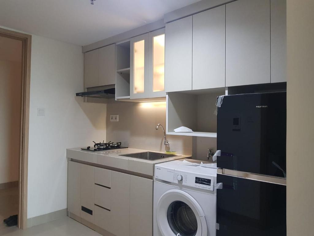 une cuisine avec un lave-linge et un lave-linge dans l'établissement Apartment Embarcardero Bintaro 1BR, à Jombang