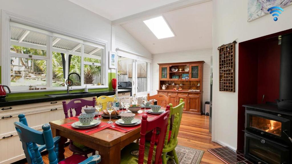 a kitchen with a table with chairs and a fireplace at Lilly Pilly Arthouse in Stanwell Park