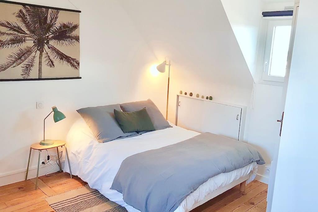 1 dormitorio con 1 cama blanca con lámpara y mesa en Ty Chou - Appartement Cosy - Centre Ville, en Rennes