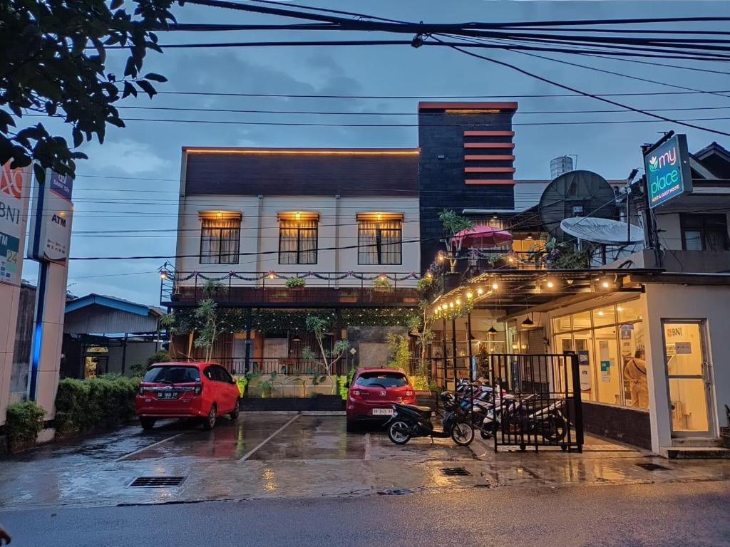 a street with cars parked in front of a building at My Place Guest House Manado in Manado