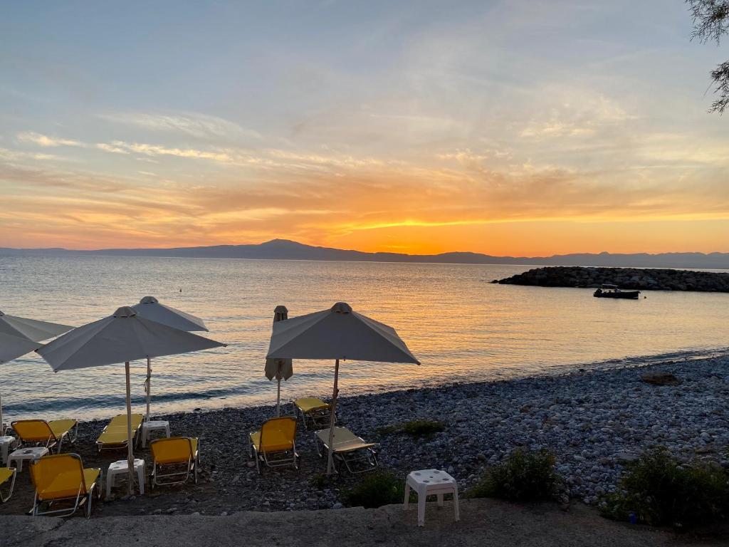 una spiaggia con sedie e ombrelloni al tramonto di Laas ad Avía