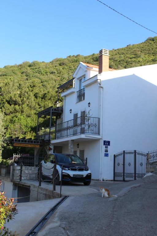 a car parked in front of a white house at Villa Lime in Petrovac na Moru