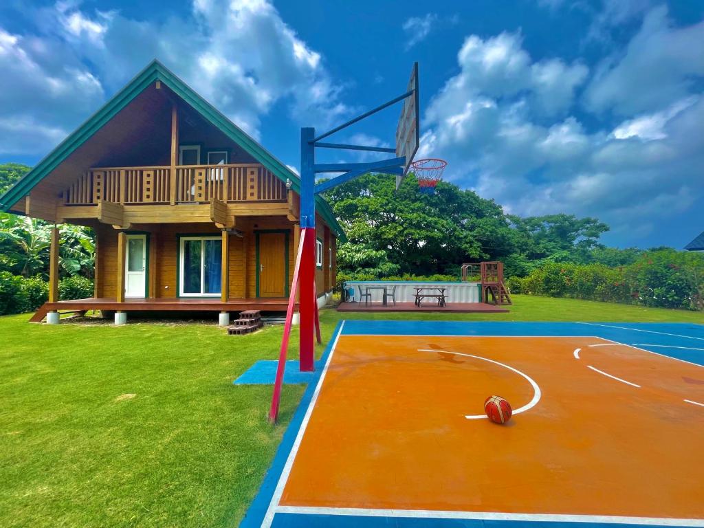 una casa con una cancha de baloncesto y un aro de baloncesto en レジーナ石垣　ログテリアⅠ, en Hirakubo