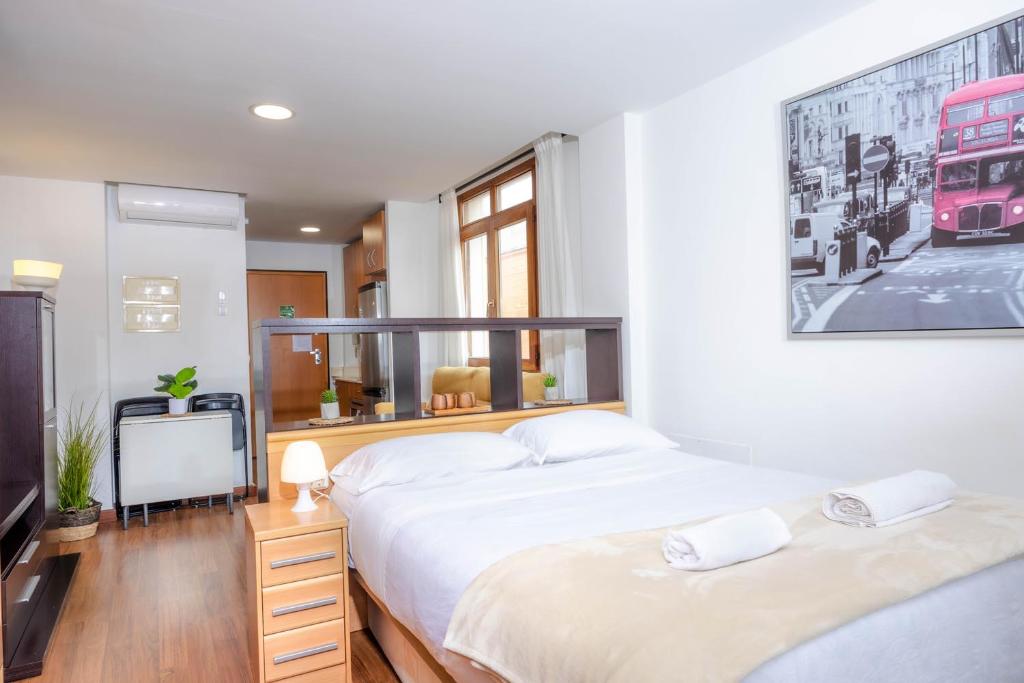 duas camas num quarto com uma fotografia de autocarro na parede em Apartamentos Turísticos Distrito Romano em Cartagena