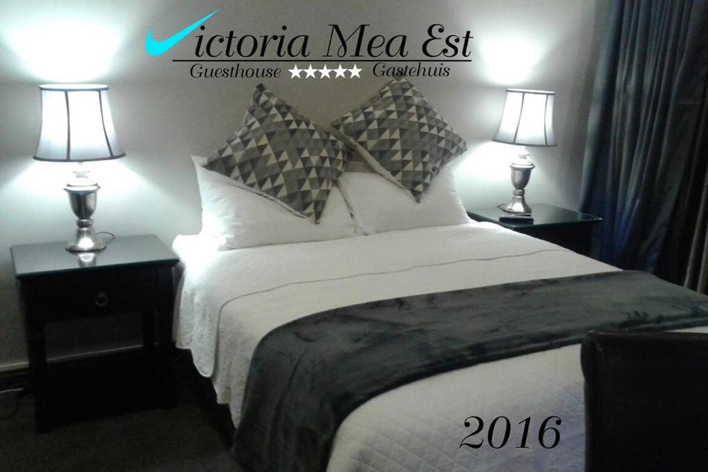 a hotel room with a bed with two lamps at Victoria Mea Est in Welkom