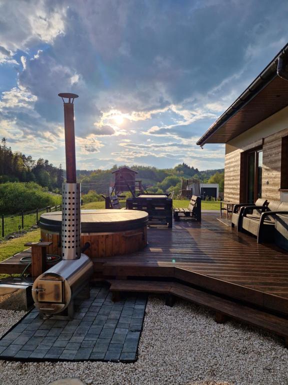 a wooden deck with a hot tub and a grill at Domek w Paszynie - Sauna i Gorąca balia in Paszyn