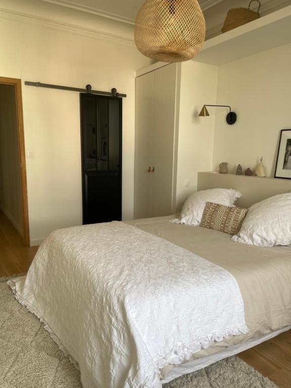 a bedroom with a large bed with white sheets at Grande chambre cosy in Marseille