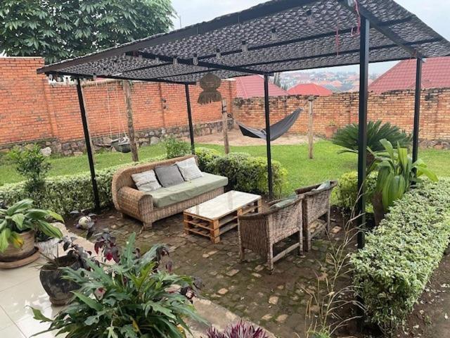um pátio com um sofá e uma rede de descanso num jardim em grande villa verdoyante à louer pour 1 mois em Kigali