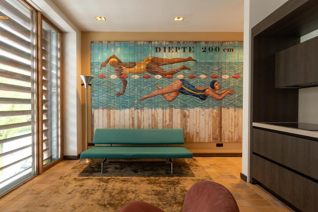 ein Wohnzimmer mit einer blauen Bank und einem Gemälde in der Unterkunft Appartement Globo in Middelburg