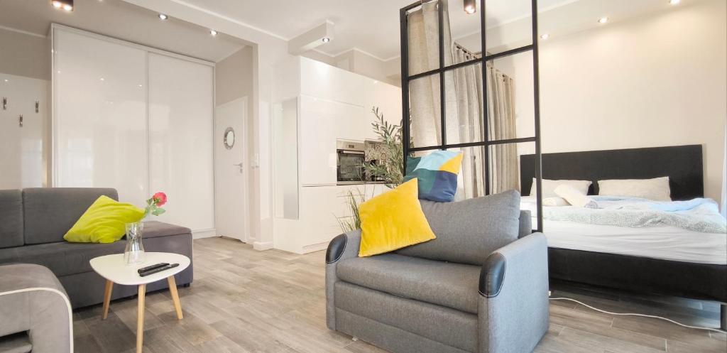 a living room with a couch and a bed at Central Apartments Neptun Park 1 & Parking in Gdańsk