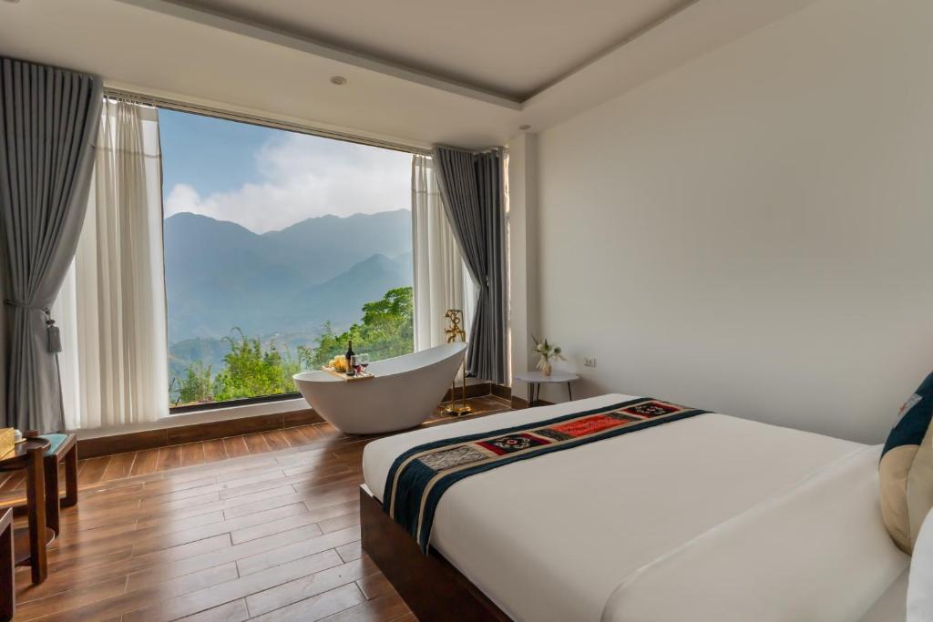 a bedroom with a tub and a large window at Sapa Heaven House in Sa Pả