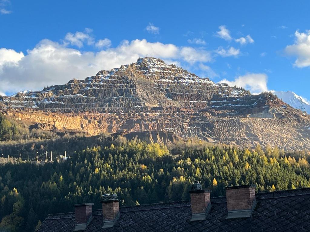 una montaña cubierta de nieve frente a una casa en Haus Erzbergblick, en Eisenerz