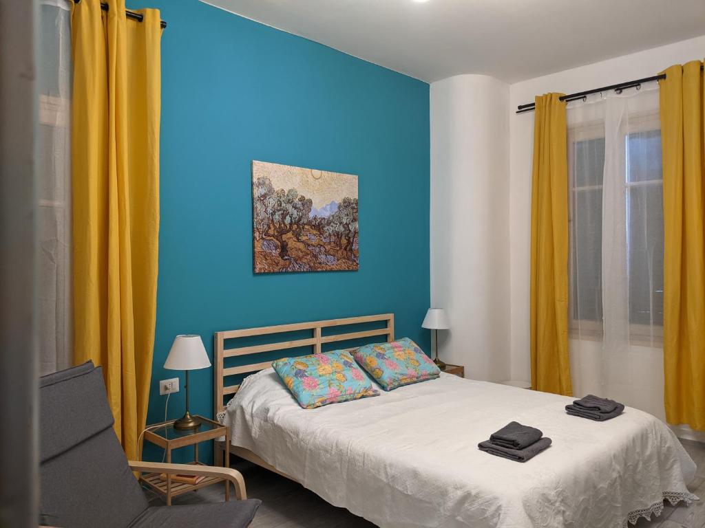 a blue bedroom with a bed and a chair at lake dreams in Verbania