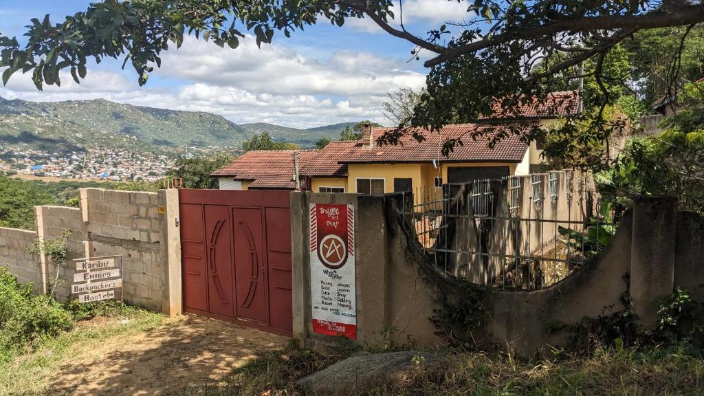 una casa con un cancello rosso e una recinzione di Safari Junction Backpackers hostel a Iringa