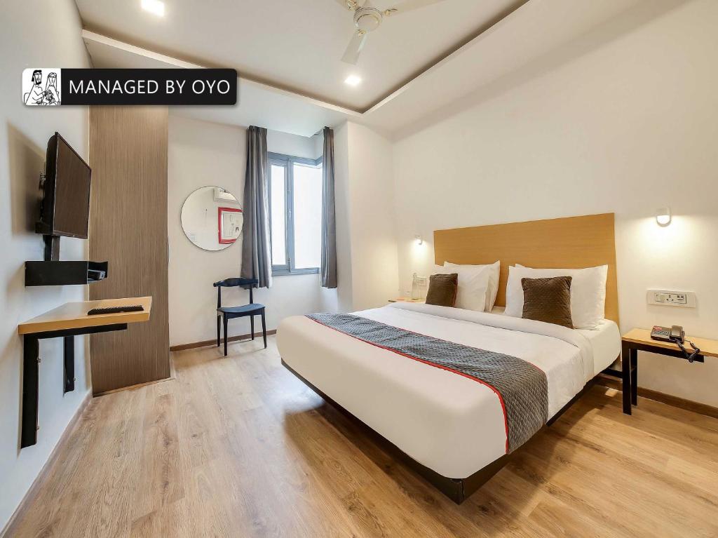 a hotel room with a large bed and a desk at Super Townhouse Rohini Sector 24 in New Delhi
