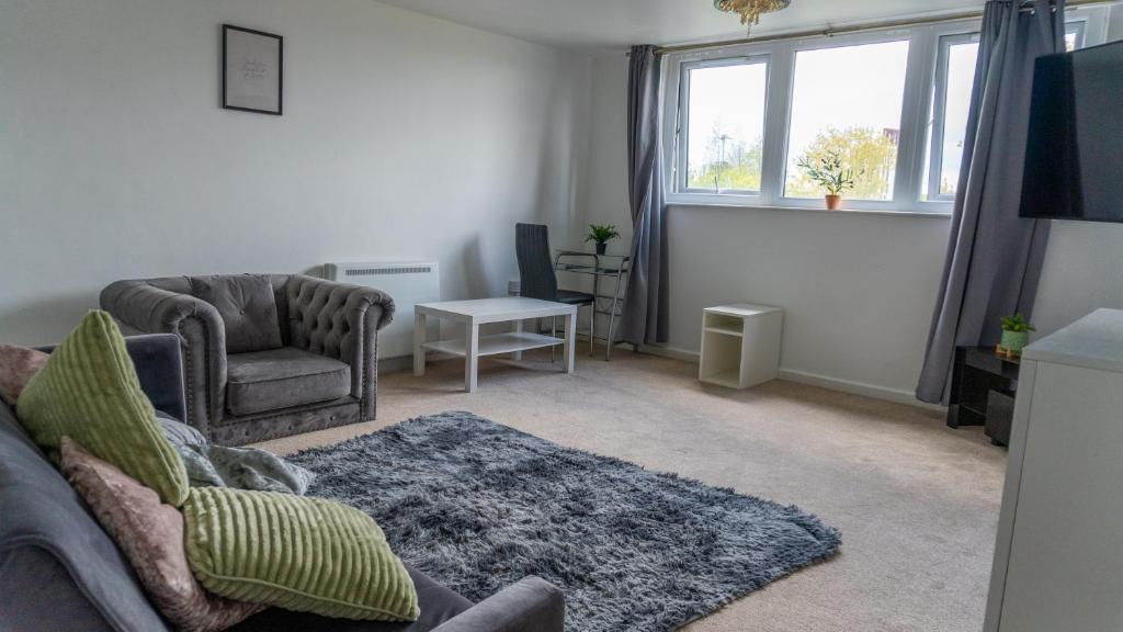 a living room with a couch and a chair and a window at 2 Bed - City Centre Apartment - Long Stay Rates - Perfect for Families, Contractors and Professionals in Leeds