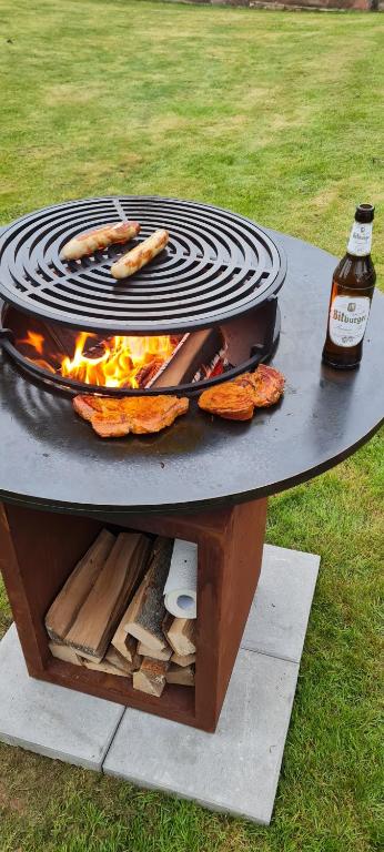 a barbecue grill with food and a bottle of beer at Ferienhaus Paul in Neidenbach