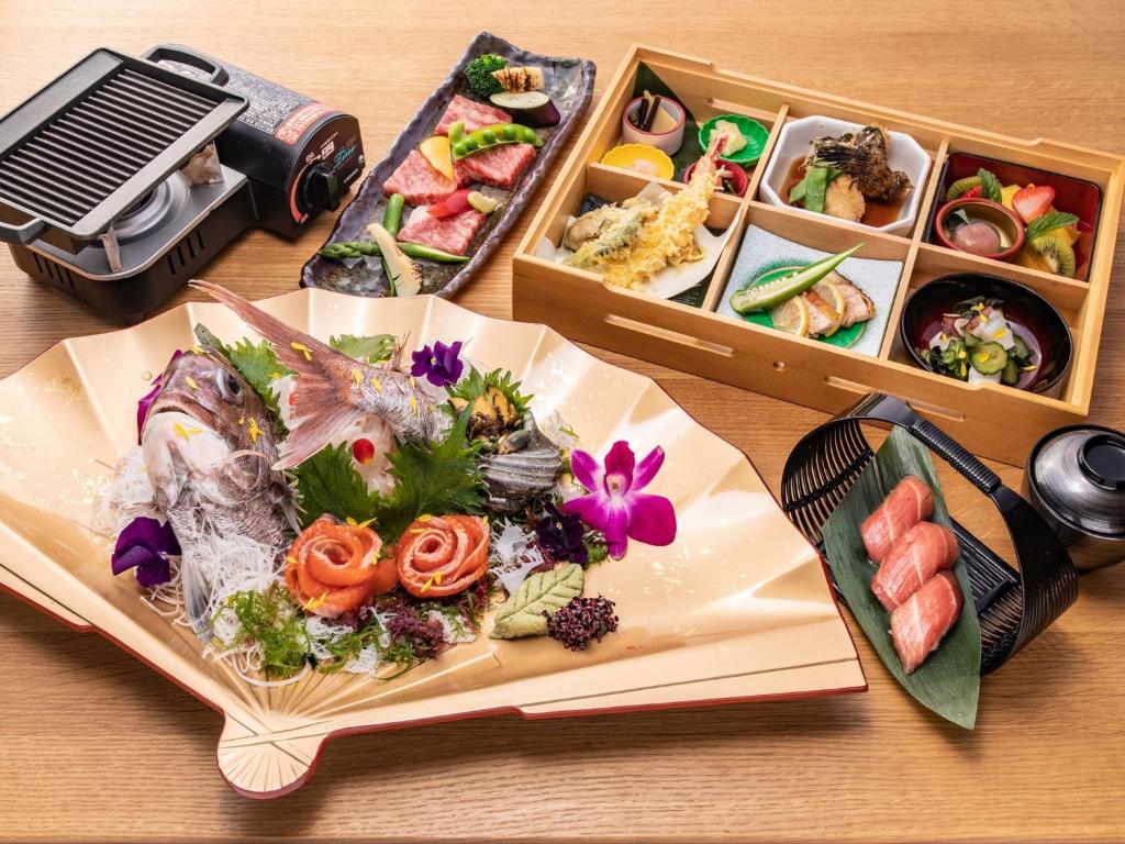 a table with a plate of food and two boxes of sushi at Setouchi Resort Villa - Vacation STAY 07952v in Takekara