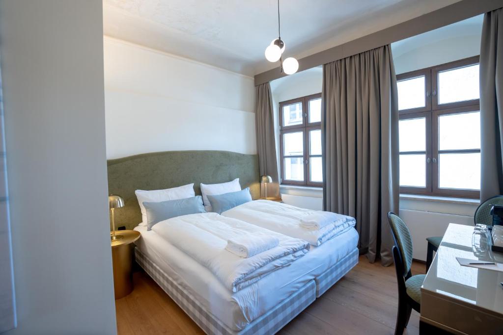 Postel nebo postele na pokoji v ubytování Maxim Suites by Elias Holl