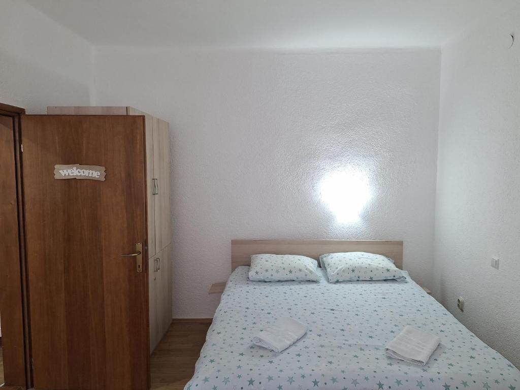 ein kleines Schlafzimmer mit einem Bett und einem Holzschrank in der Unterkunft Apartmani Ružica in Višegrad