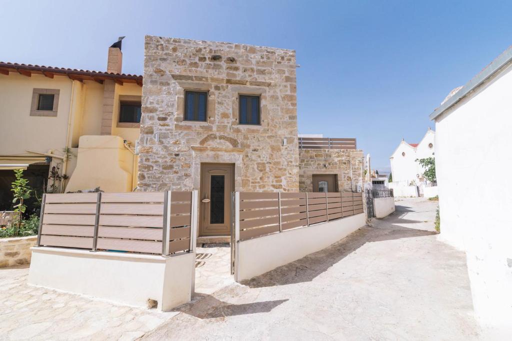 une maison avec une clôture en bois devant elle dans l'établissement Fedra House, à Vóroi