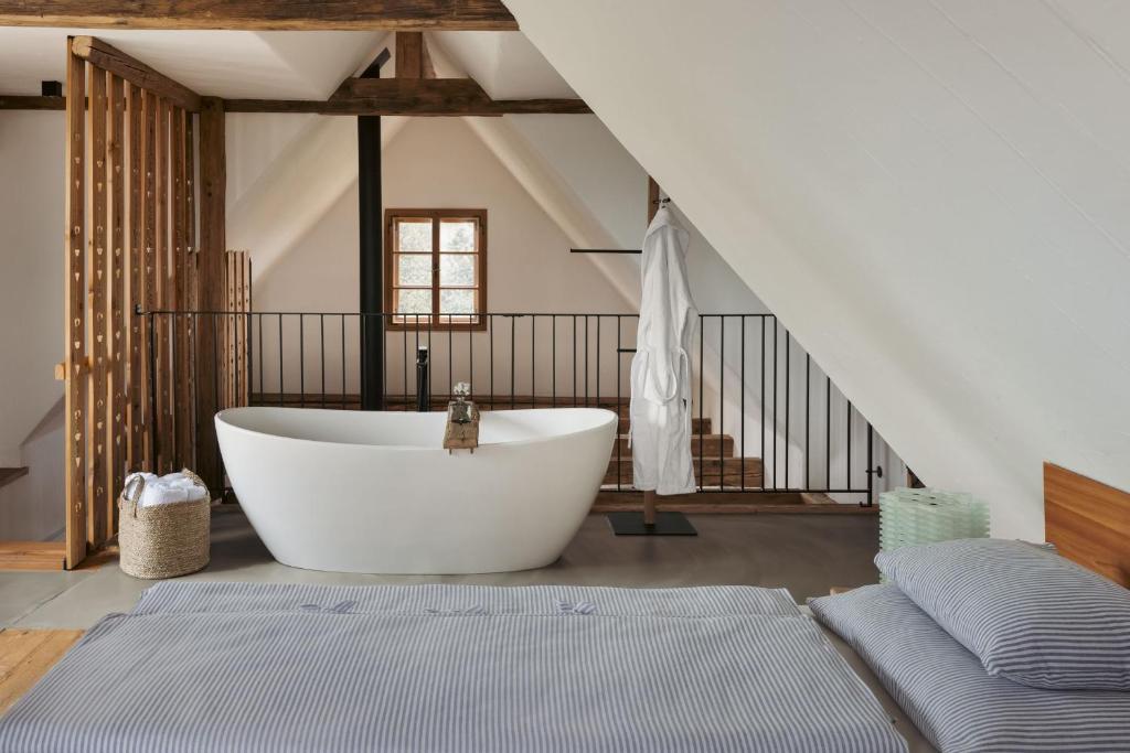 a bathroom with a large white tub in a room at AM WILDBACHBERG Luxus Ferienhäuser mit Infinitypool, Weinkeller und Privatsauna in Deutschlandsberg