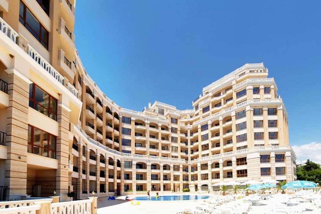 - un grand bâtiment avec une piscine en face dans l'établissement Cabacum Beach Residence - free parking, à Varna