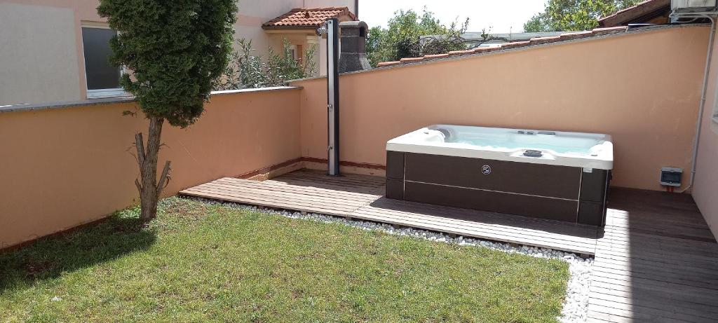 a hot tub sitting on a deck next to a house at Apartment Onbria Mar in Medulin